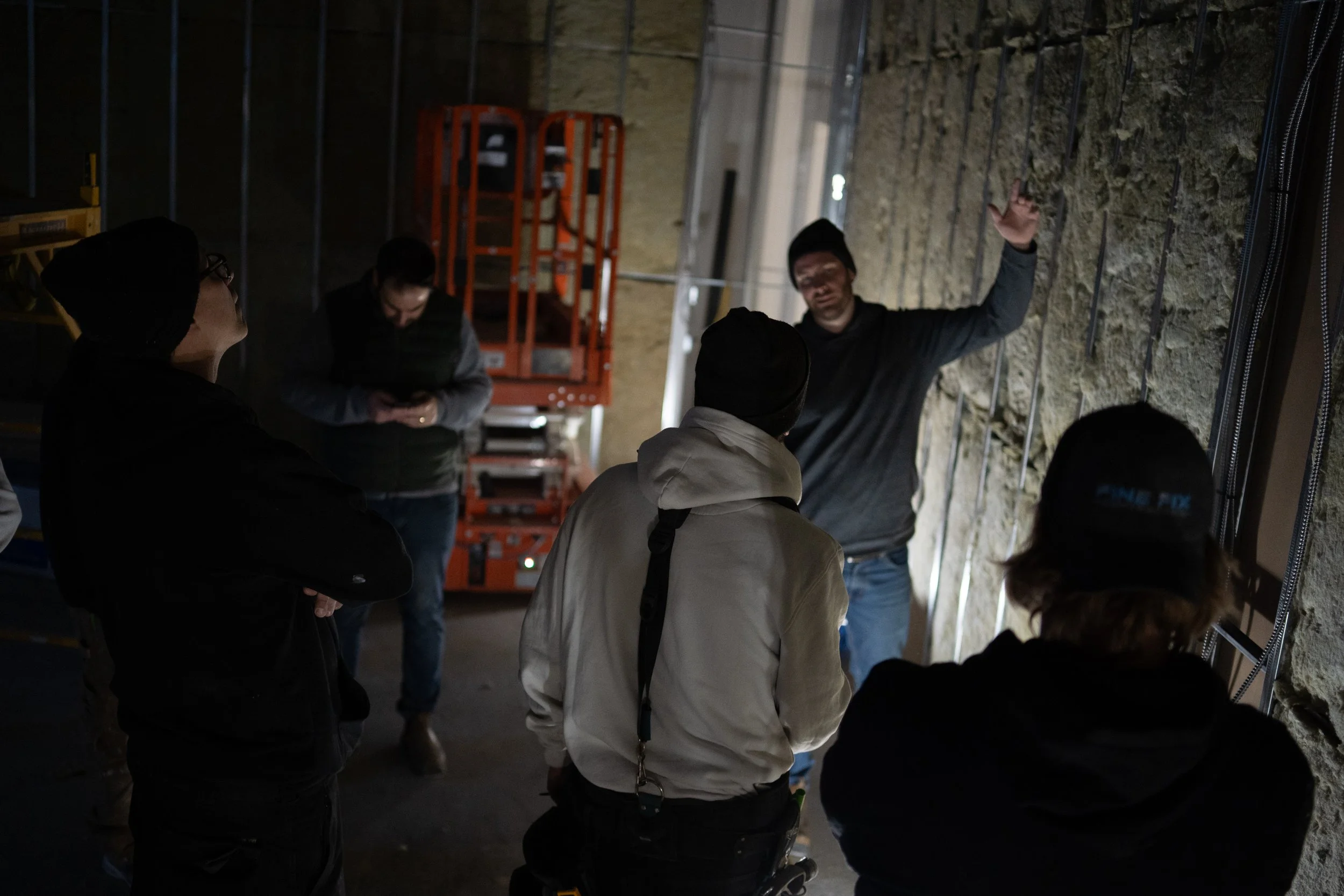 Skilled tradesperson texting a question to FineFix AI for an instant answer on their smartphone, concrete mixer in background