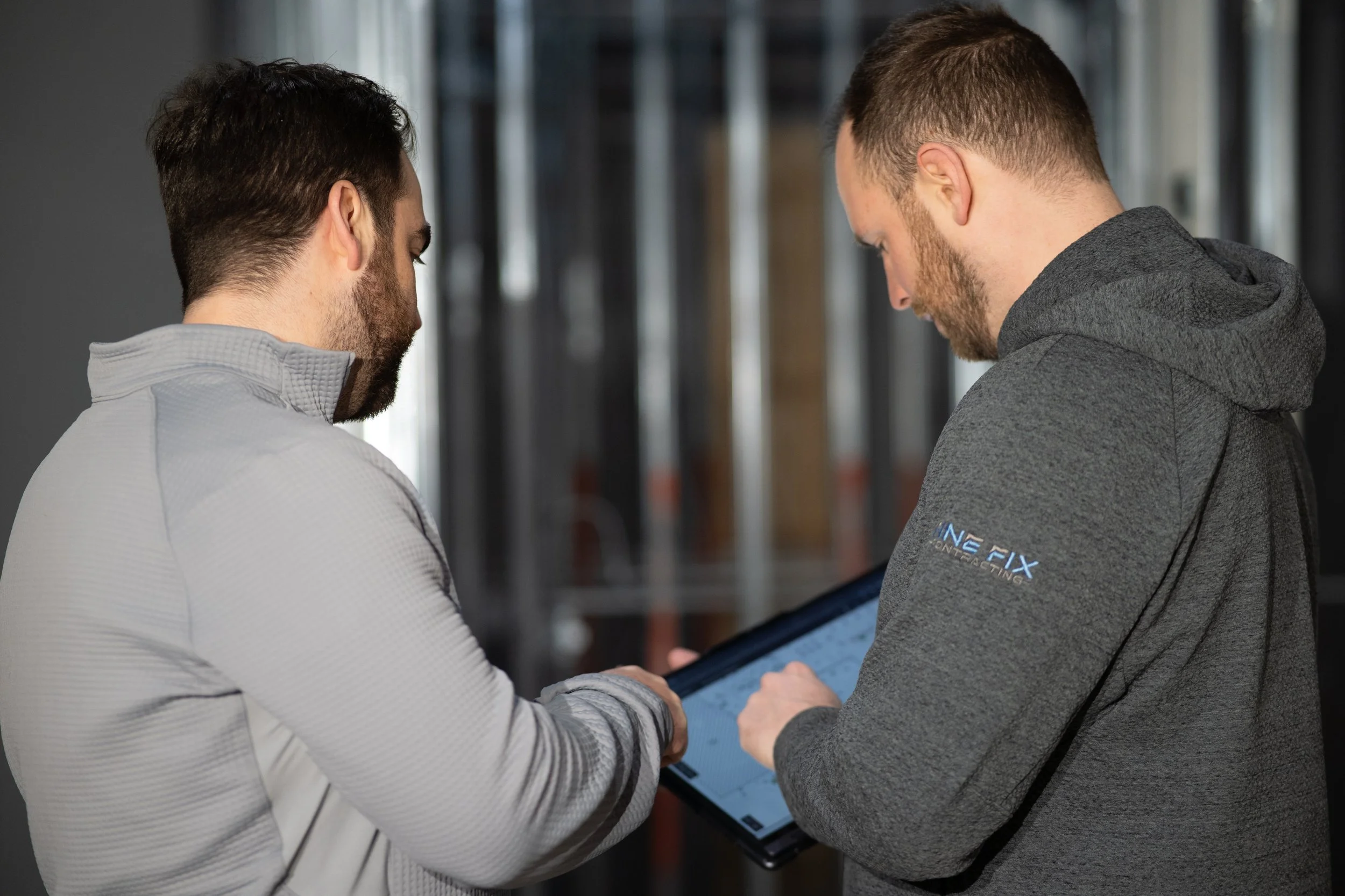 Field worker viewing FineFix Knowledge Base on a rugged tablet, with dusty construction site in background
